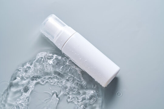 水中的化妆品瓶装产品在蓝色背景上。高质量照片。水中的化妆品瓶装产品在蓝色背景上。